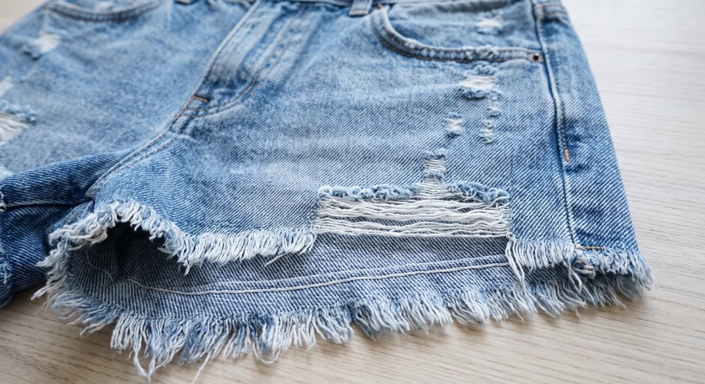 High rise vintage distressed denim cutoff shorts with raw frayed hem detail