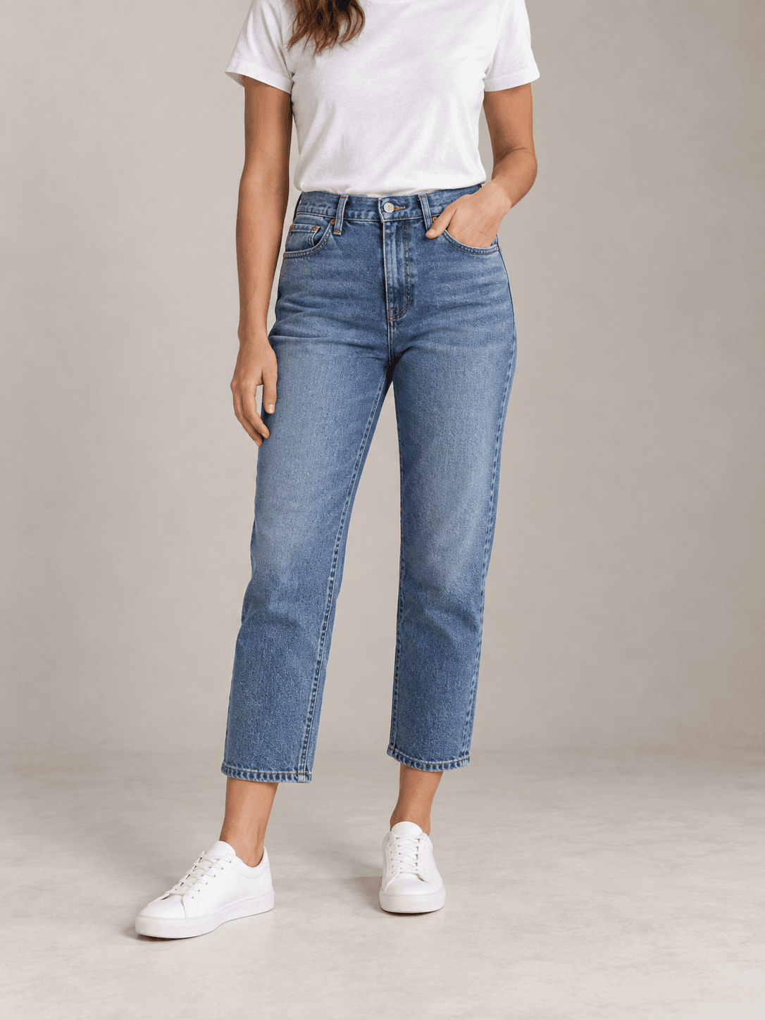 Women's medium-blue cropped jeans styled with white sneakers